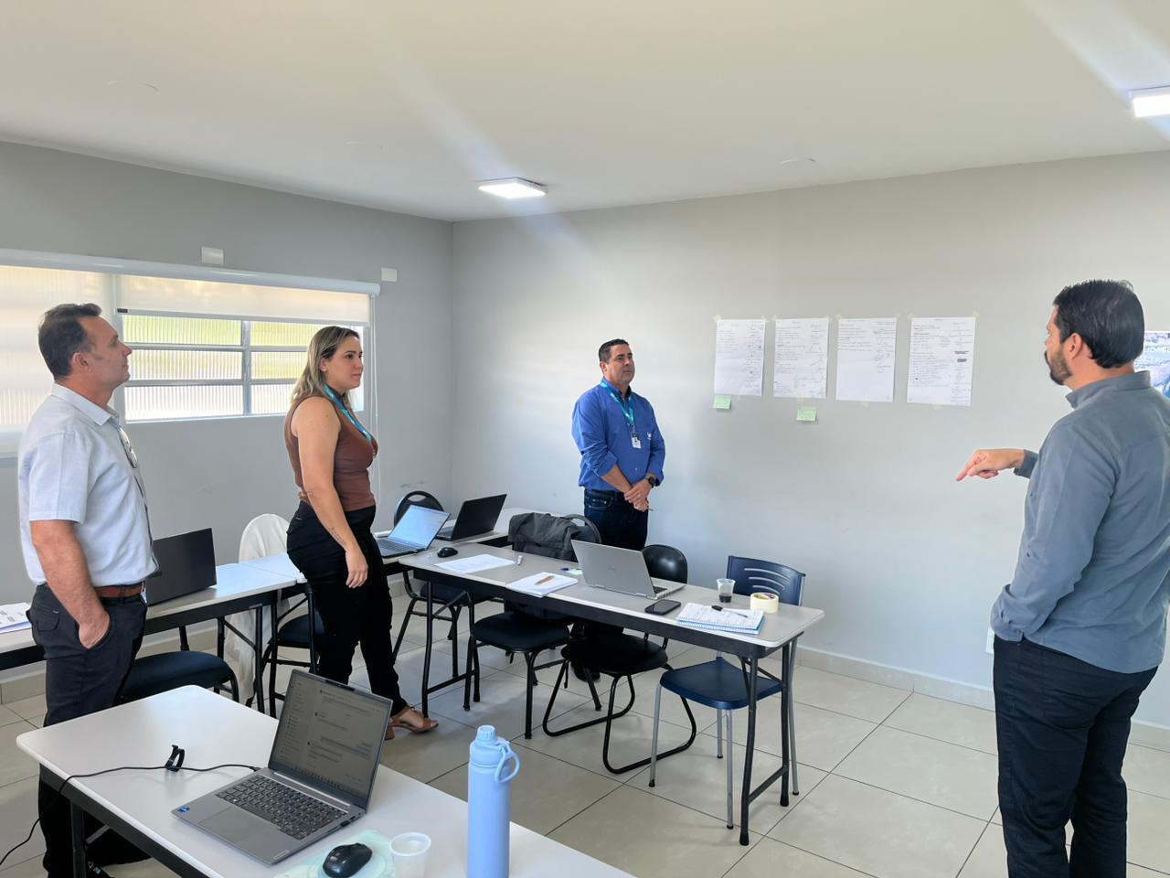 Reunião de mapeamento in loco com colaboradores da WANA discutindo os fluxos registrados na parede